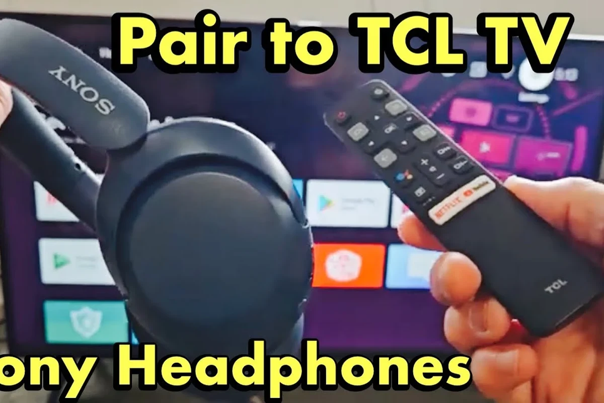 Person pairing Bluetooth headphones with a TCL Roku TV in a living room