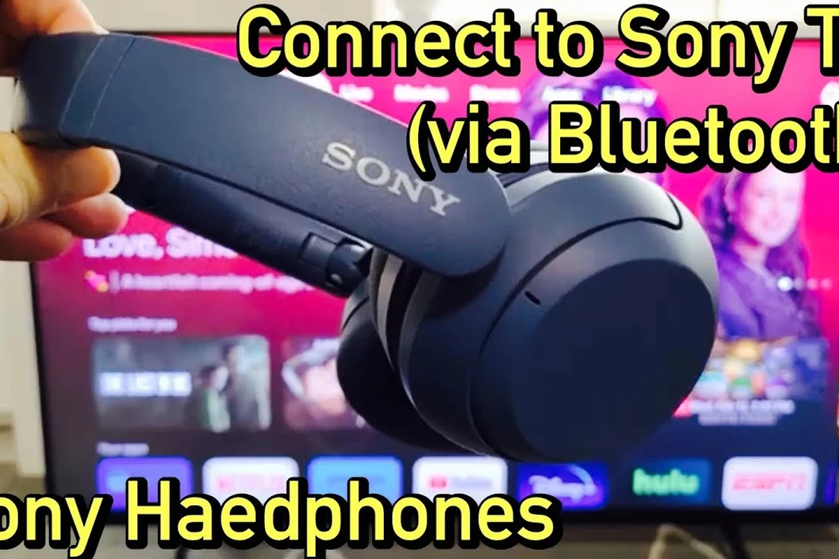 Person using wireless headphones with a modern TV in a living room