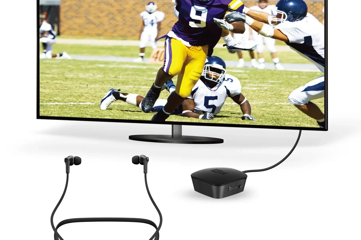 Person connecting wireless headphones to a TV for private listening in a living room