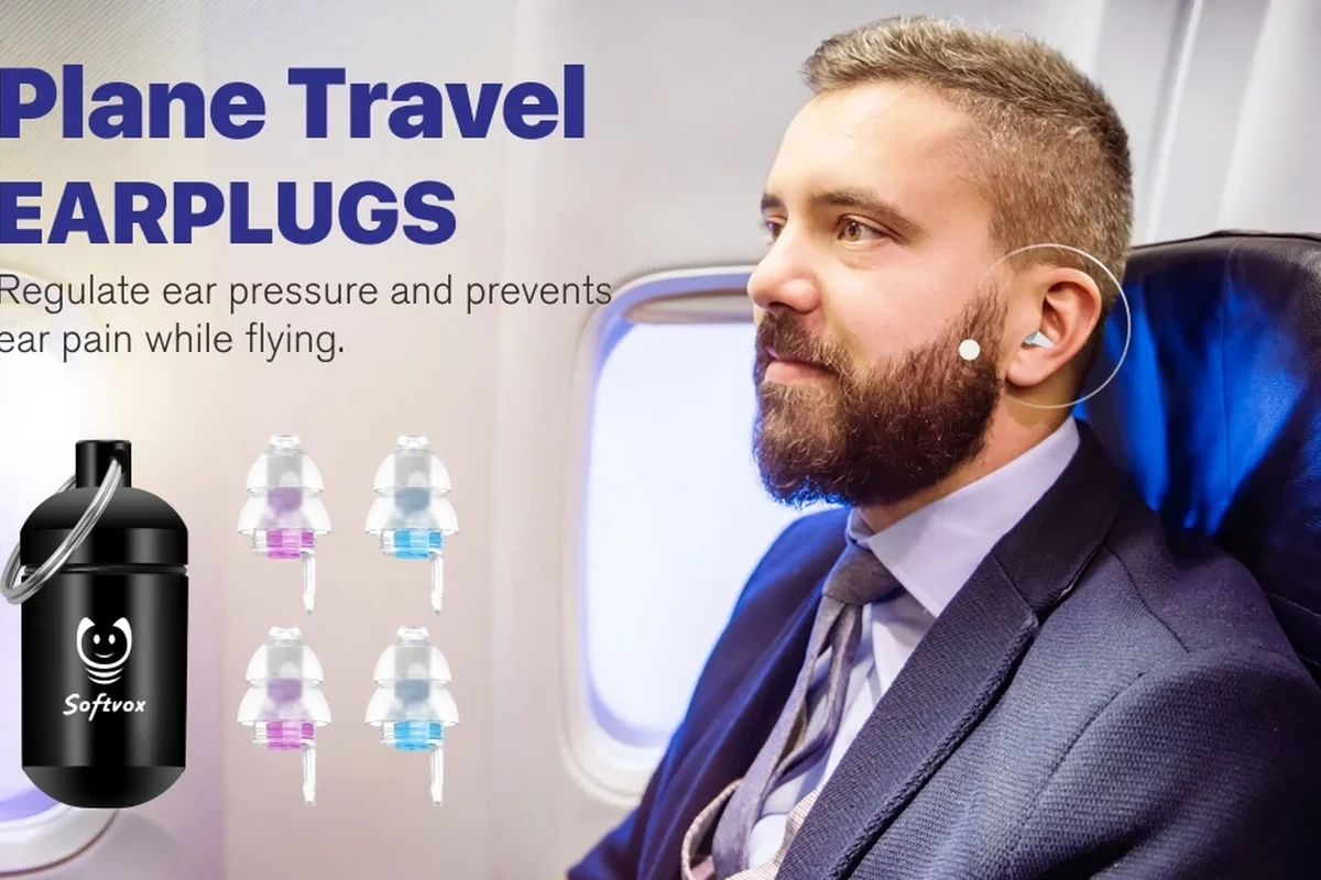 Traveler wearing noise-canceling headphones on an airplane seat during a flight