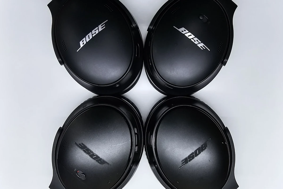 Bose headphones and earbuds arranged with model labels, serial numbers, and app pairing clues