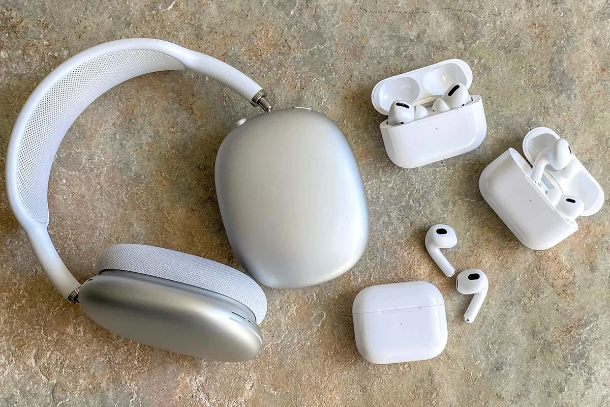 Apple headphones on a desk with packaging, serial number label, and phone for authenticity checks