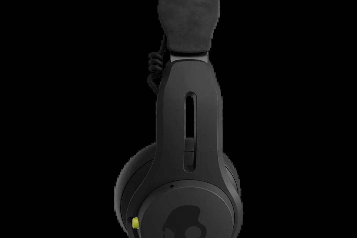Skullcandy headphones on a desk with charging cable and soft case