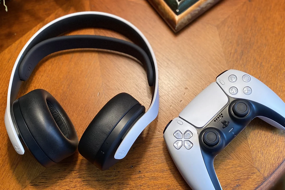 PS5 console with gaming headphones connected by wireless dongle and controller cable