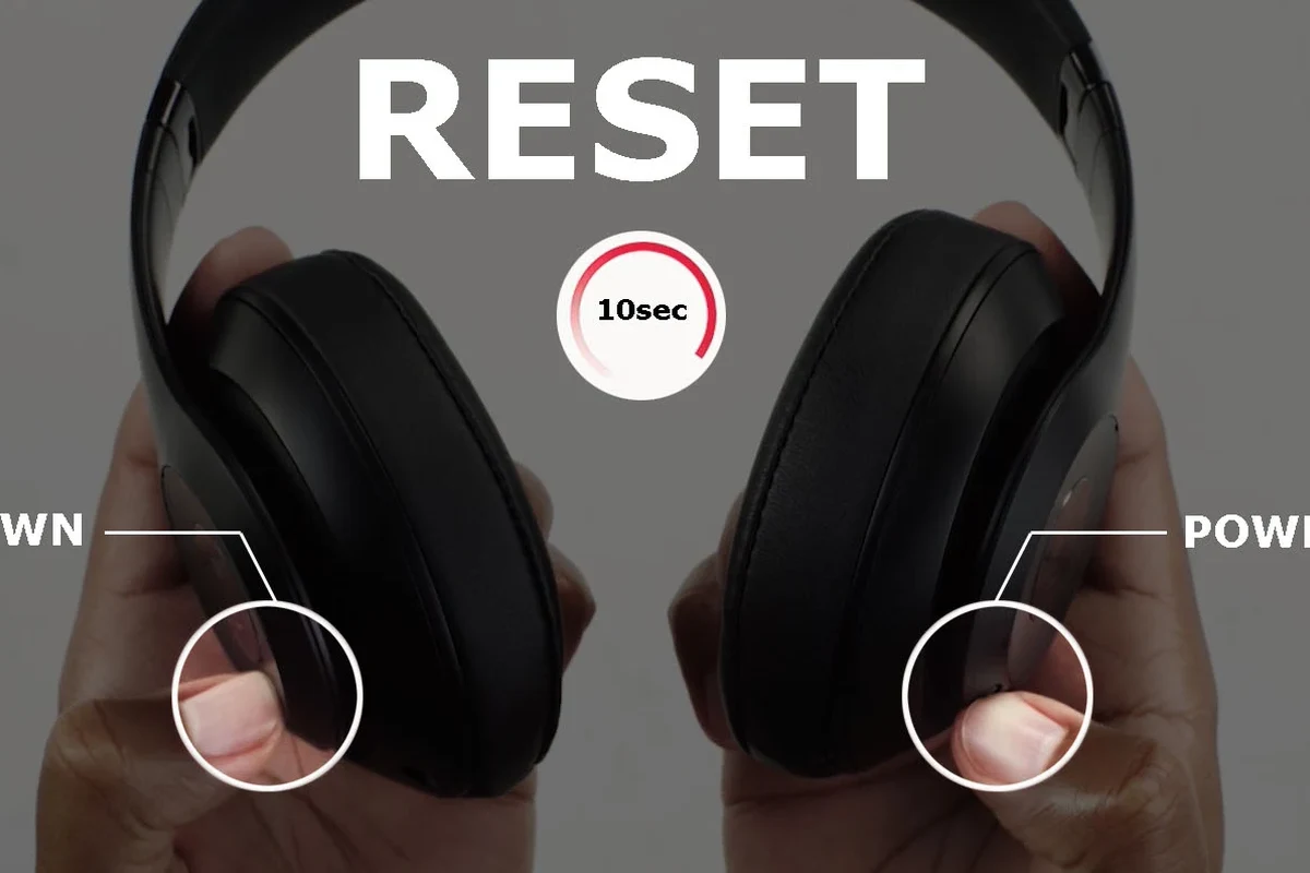 Person restarting Beats headphones while checking Bluetooth connection on a phone