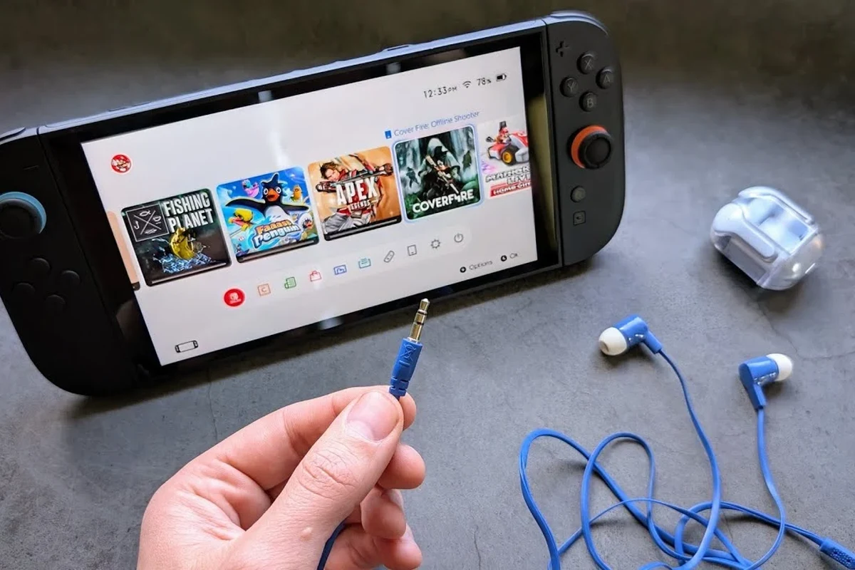 Nintendo Switch 2 handheld gaming console with wired headphones plugged into the 3.5mm audio jack