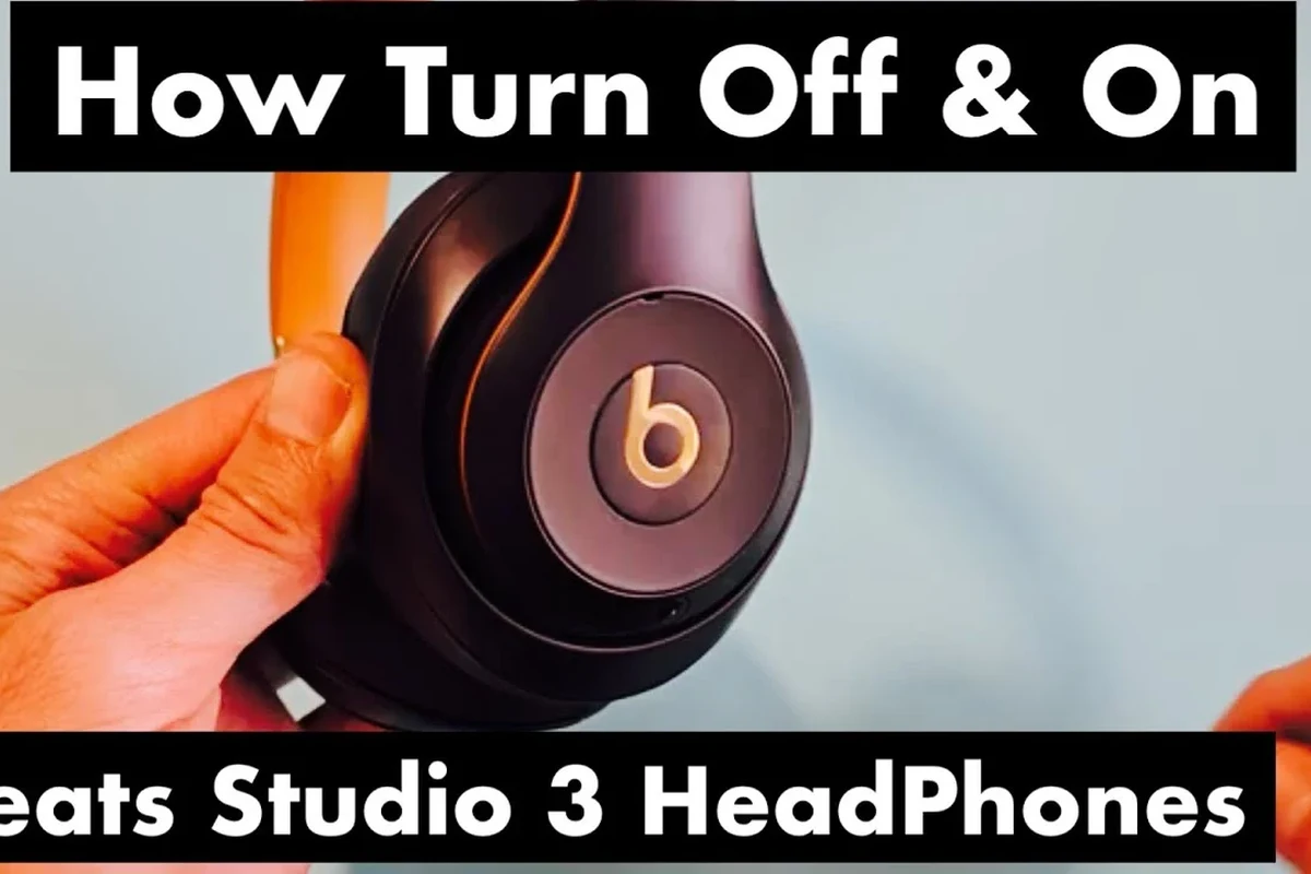 Person turning off Beats headphones with a power button beside a charging case