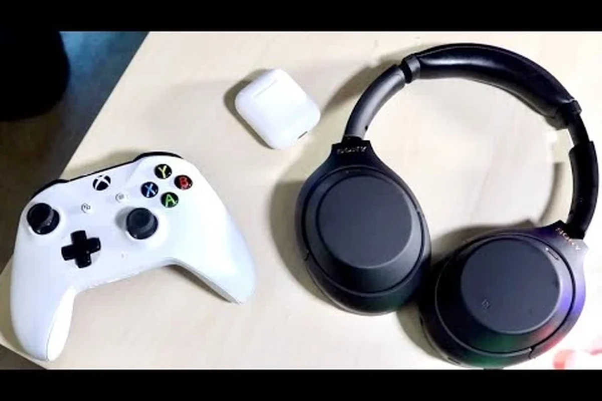 Xbox gamer using Bluetooth headphones with a wireless transmitter setup on a TV