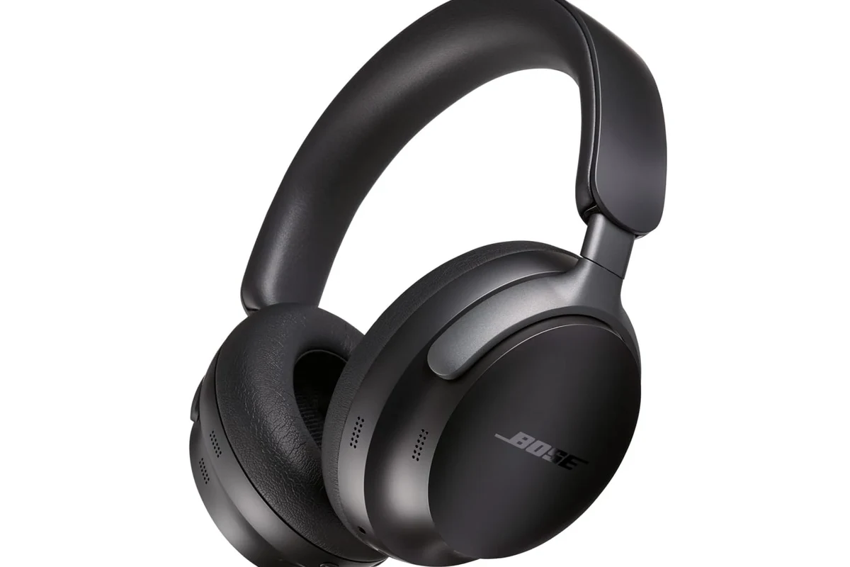 Person adjusting Bose QC over-ear headphones for comfortable listening and noise cancellation