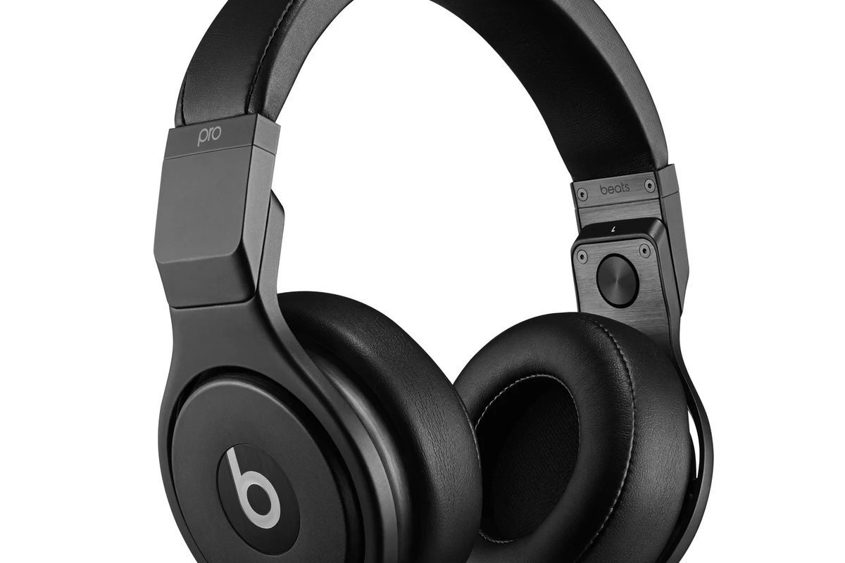 Person using Beats-style wireless headphones while pairing and adjusting sound settings on a phone