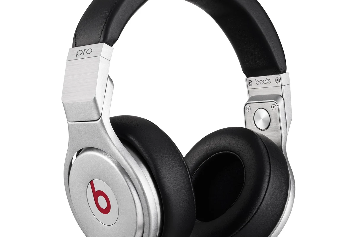 Person using Beats-style wireless headphones while pairing and adjusting sound settings on a phone