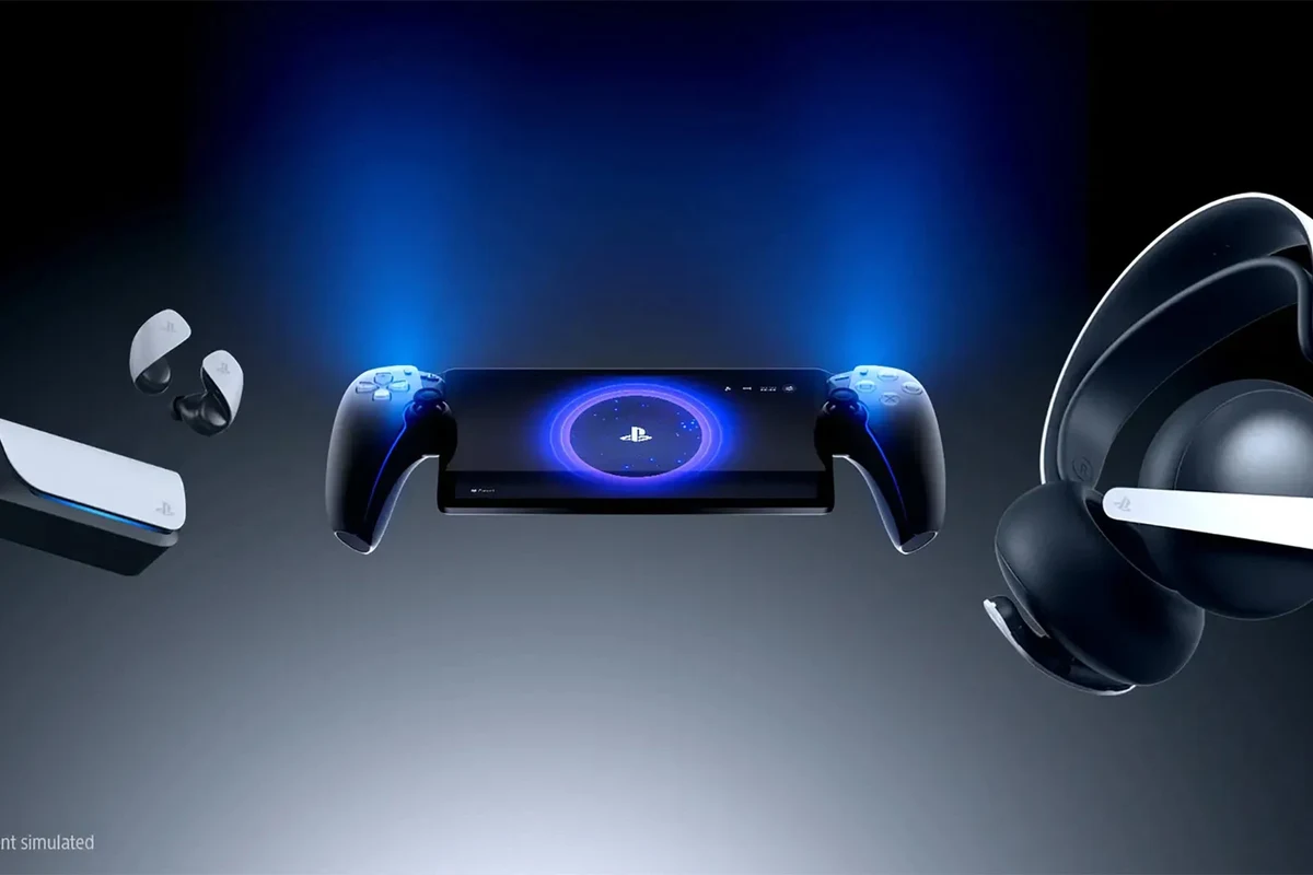 PlayStation Portal handheld gaming device with compatible headphones nearby on a desk