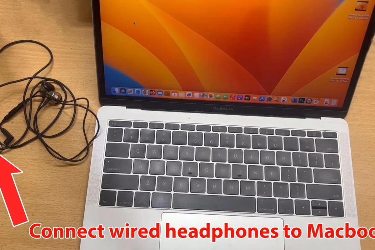 Wired headphones connected to a MacBook laptop with USB-C adapter