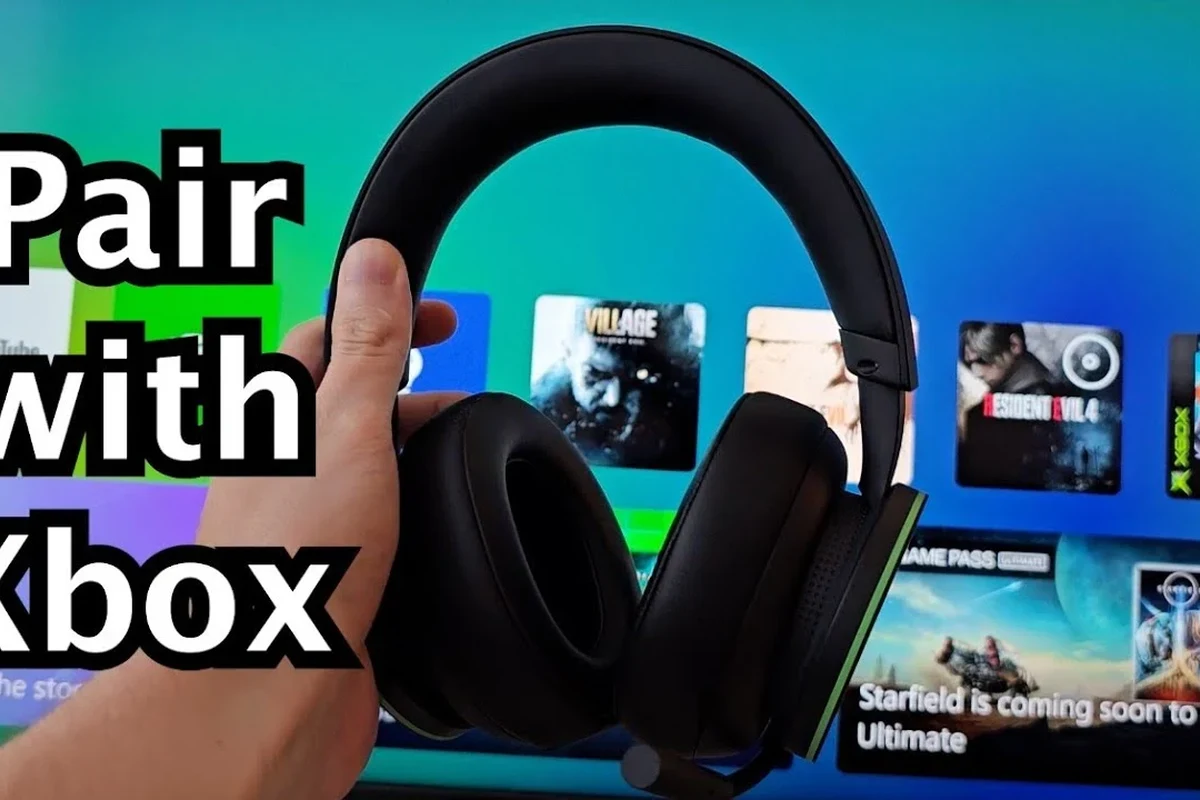 Wireless gaming headset connected to an Xbox console beside a TV in a living room