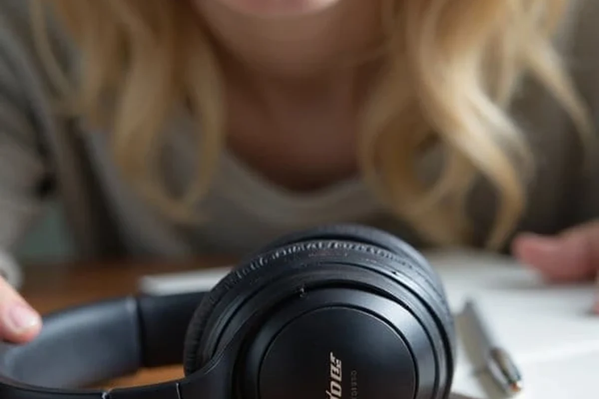 Person asking how to pronounce Bose headphones correctly beside a pair of premium over-ear headphones