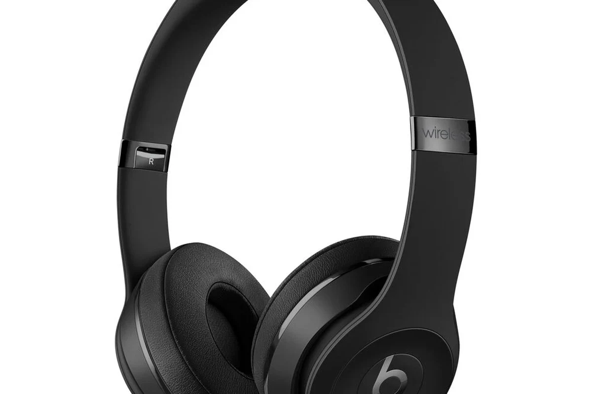 Beats headphones on a desk beside a charging cable and trade-in shipping box