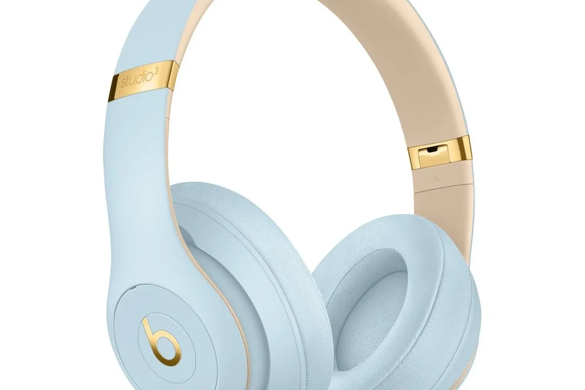 Beats headphones on a desk beside a charging cable and trade-in shipping box