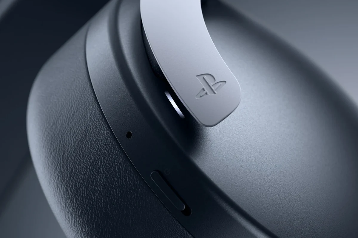 PS5 gaming headset on a clean desk beside a console controller and monitor